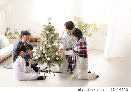 Family decorating a Christmas tree: mother, father, grandmother, daughter, younger brother and baby, wide-angle Family decorating a Christmas tree: mother, father, grandmother, daughter, younger brother and baby, wide-angle 117414800