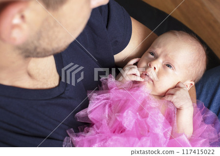 Newborn baby girl in the arms of her dad. 117415022