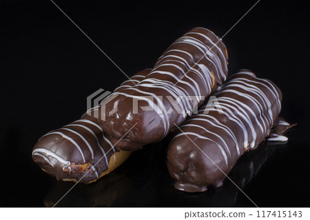 Cake chocolate eclairs on a dark background close up Cake chocolate eclairs on a dark background close up 117415143