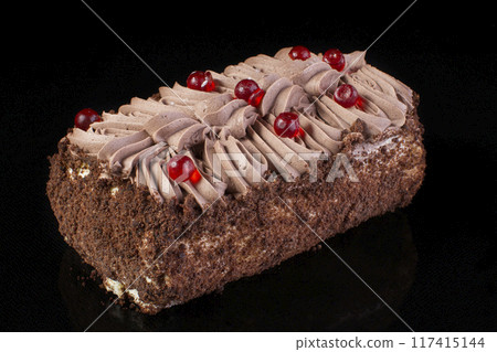 Biscuit roll with chocolate cream on a black background Biscuit roll with chocolate cream on a black background 117415144