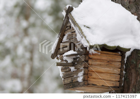 Wooden birdhouse. House for birds in the winter forest Wooden birdhouse. House for birds in the winter forest 117415397