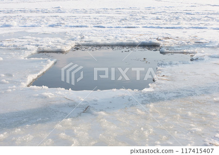 A pond in the icy lake in the form of a cross for the feast of the baptism of the Lord 117415407