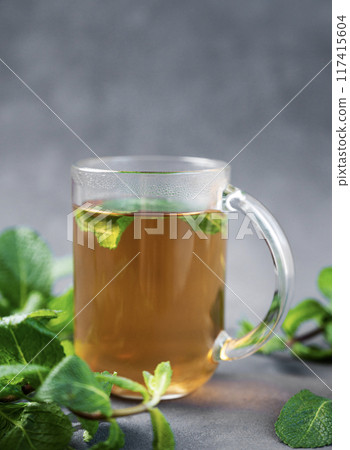 Aroma a glass of herbal tea with mint on a dark background close up.  117415604