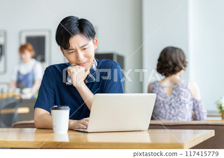 年輕人在咖啡館看電腦 117415779