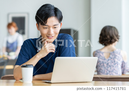 年輕人在咖啡館看電腦 117415781