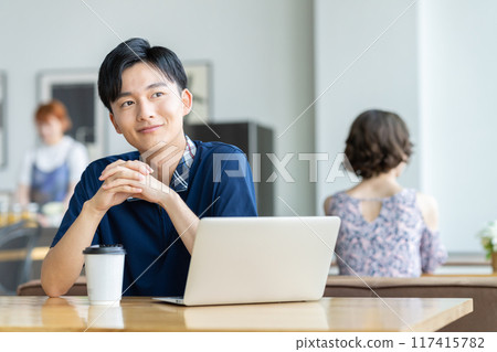 年輕人在咖啡館看電腦 117415782