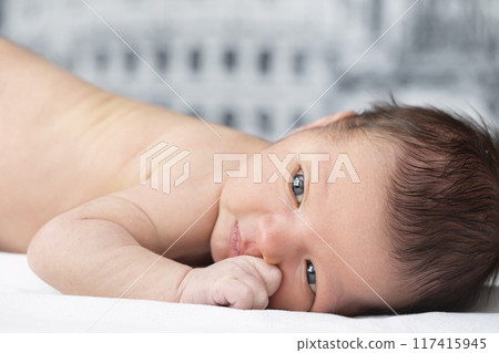 Close-up newborn baby portrait. A baby with smart eyes. 117415945