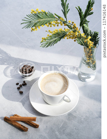 Cappuccino or latte with milk foam in a white cup on a light blue background with coffee beans Cappuccino or latte with milk foam in a white cup on a light blue background with coffee beans 117416148