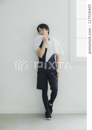 Young man in sportswear wiping sweat with a towel 117416405