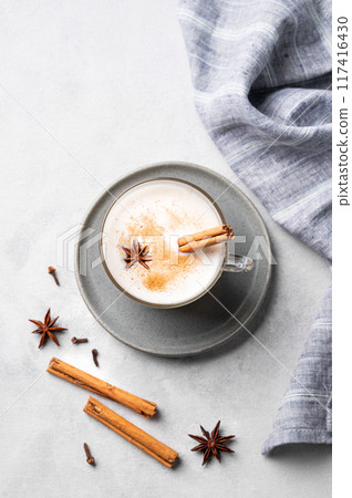 Traditional Indian masala chai latte in a glass cup. Hot drink with milk, spices and herbs Traditional Indian masala chai latte in a glass cup. Hot drink with milk, spices and herbs 117416430