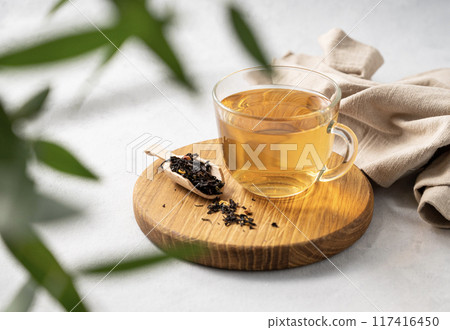 Fragrant herbal tea in a glass cup on a cutting board and white background with eucalyptus  117416450
