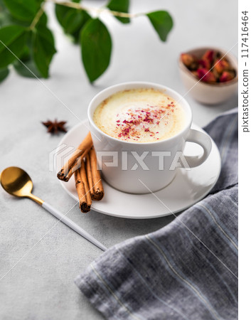 Golden milk latte with turmeric and rose petals. Trendy Indian drink Moon milk with natural spices. Golden milk latte with turmeric and rose petals. Trendy Indian drink Moon milk with natural spices. 117416464