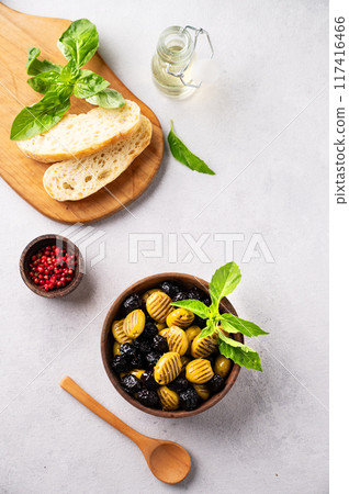 A set of green and black dried olives in wooden bowl  with fresh chiabatta bread  117416466