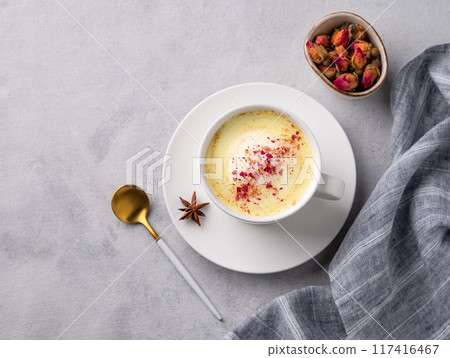 Golden milk latte with turmeric and rose petals. Trendy Indian drink Moon milk with natural spices. Golden milk latte with turmeric and rose petals. Trendy Indian drink Moon milk with natural spices. 117416467