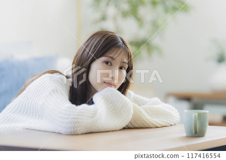 A young woman in knitwear relaxing in a room 117416554