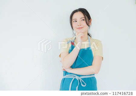 A woman in an apron thinking 117416728