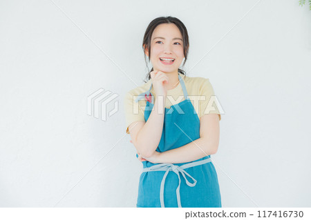 A woman in an apron thinking 117416730