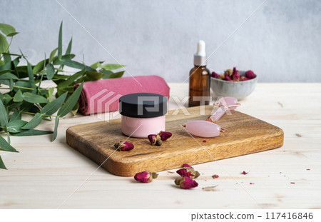 The concept of face and body care cosmetics with rose and eucalyptus. Face cream and massager The concept of face and body care cosmetics with rose and eucalyptus. Face cream and massager 117416846