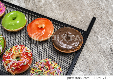 A tray of assorted mini donuts with a chocolate one in the middle 117417122