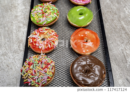 A tray of colorful mini donuts with sprinkles on top 117417124