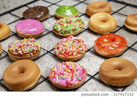 A tray of assorted mini donuts with sprinkles and frosting A tray of assorted mini donuts with sprinkles and frosting 117417132
