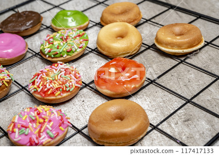 A tray of assorted mini donuts with sprinkles and frosting A tray of assorted mini donuts with sprinkles and frosting 117417133