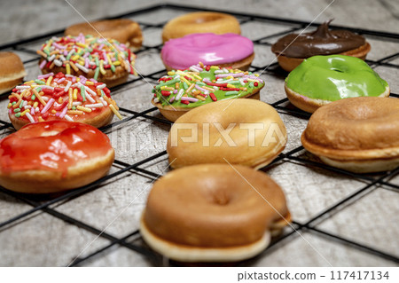 A tray of assorted mini donuts with sprinkles and frosting A tray of assorted mini donuts with sprinkles and frosting 117417134