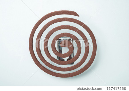 Mosquito coils with a silver object in the middle 117417268