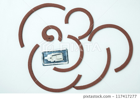 Mosquito coils with a silver object in the middle 117417277