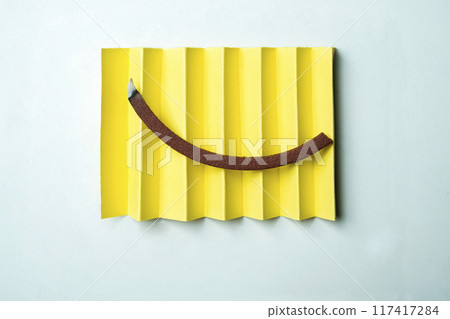 A yellow piece of paper with a mosquito coils on it 117417284