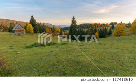 romania countryside at dusk. wonderful autumn landscape in mountains. grassy field and rolling hills. trees in fall colors. outskirts of village in apuseni mountains. rural scenery romania countryside at dusk. wonderful autumn landscape in mountains. grassy field and rolling hills. trees in fall colors. outskirts of village in apuseni mountains. rural scenery 117418610