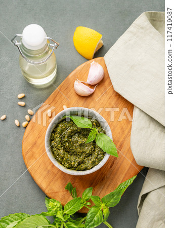 Traditional Italian pesto in a bowl with green basil, pine nuts, cheese and olive oil Traditional Italian pesto in a bowl with green basil, pine nuts, cheese and olive oil 117419087