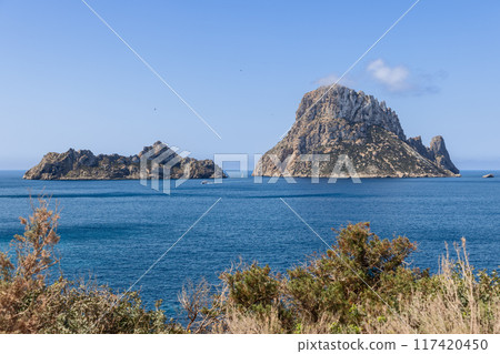 View of Es Vedra and Es Vedranell islands off Ibiza, surrounded by deep blue waters 117420450