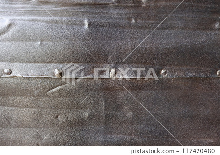 Textured metal sheet with rivets and weathered surface Textured metal sheet with rivets and weathered surface 117420480