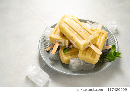 Homemade fruit yellow popsicles with mango, banana, lemon. Top view. Homemade fruit yellow popsicles with mango, banana, lemon. Top view. 117420909