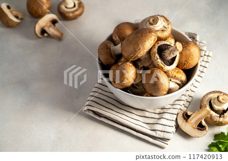 Raw champignon in a bowl on bright background, button mushrooms. Vegan protein.  117420913