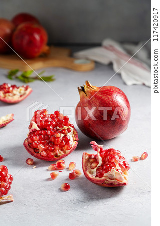 Fresh pomegranates, ripe red pomegranate slices on cutting board. Fresh pomegranates, ripe red pomegranate slices on cutting board. 117420917