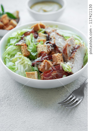 A bowl  of  Caesar salad 117421130