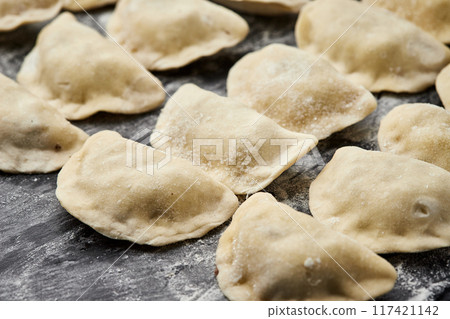 Freshly prepared homemade dumplings ready for cooking, showcasing traditional culinary skills 117421142