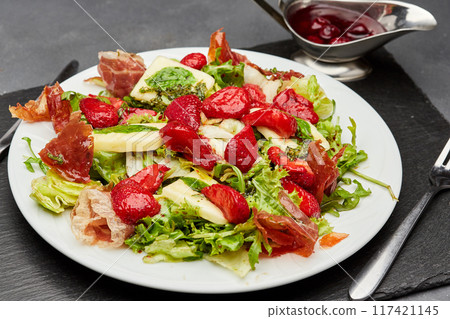 Salad with fresh strawberries, prosciutto, and mixed greens, topped with a light vinaigrette Salad with fresh strawberries, prosciutto, and mixed greens, topped with a light vinaigrette 117421145