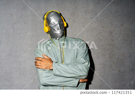 Relaxed mystery man with duct tape face wear headphones listen music Relaxed mystery man with duct tape face wear headphones listen music 117421351