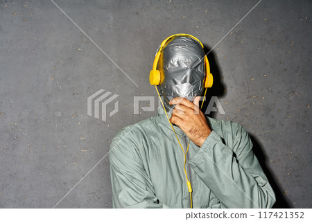 Mystery man with duct tape face wear headphones listen music Mystery man with duct tape face wear headphones listen music 117421352