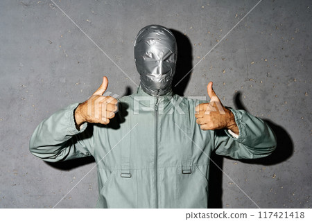 Mystery man with duct tape face showing thumbs up sign Mystery man with duct tape face showing thumbs up sign 117421418