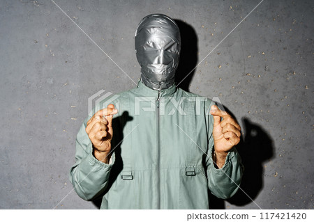 Mystery man with duct tape face makes mini heart love symbol by fingers 117421420