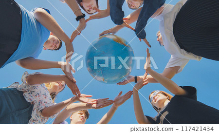 Students make a circle around the globe of the world. The concept of world peace. 117421434