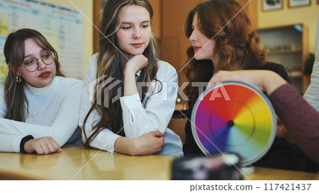 Students in physics class spin Newton's colorful wheel. 117421437