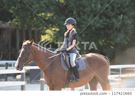 Girls enjoying horseback riding Girls enjoying horseback riding 117421660