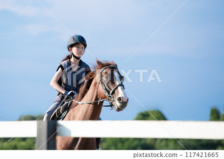 Girls enjoying horseback riding Girls enjoying horseback riding 117421665