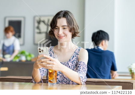 A young foreign woman relaxing in a cafe 117422110