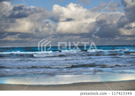 Scenic view of a dramatic ocean scene with crashing waves under a cloudy sky, 117423349